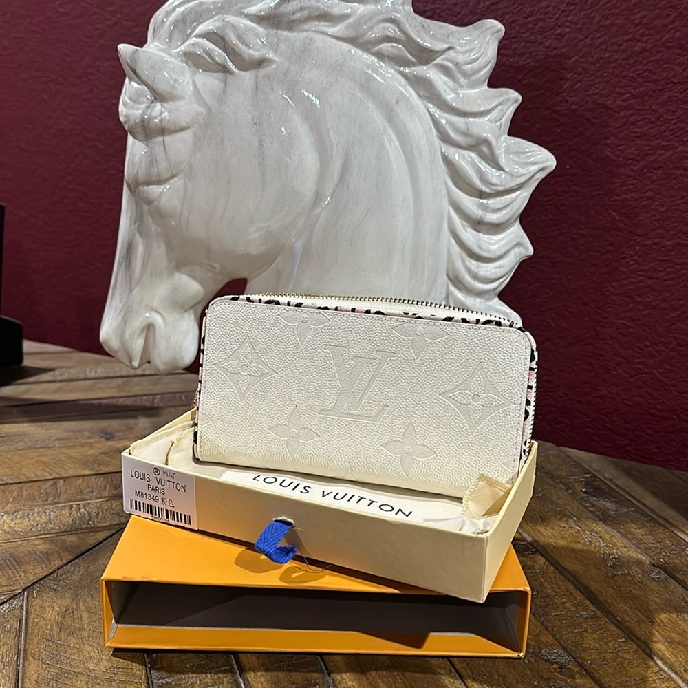 White Louis Vuitton Zipper wallet pink and white leaped detail inside.